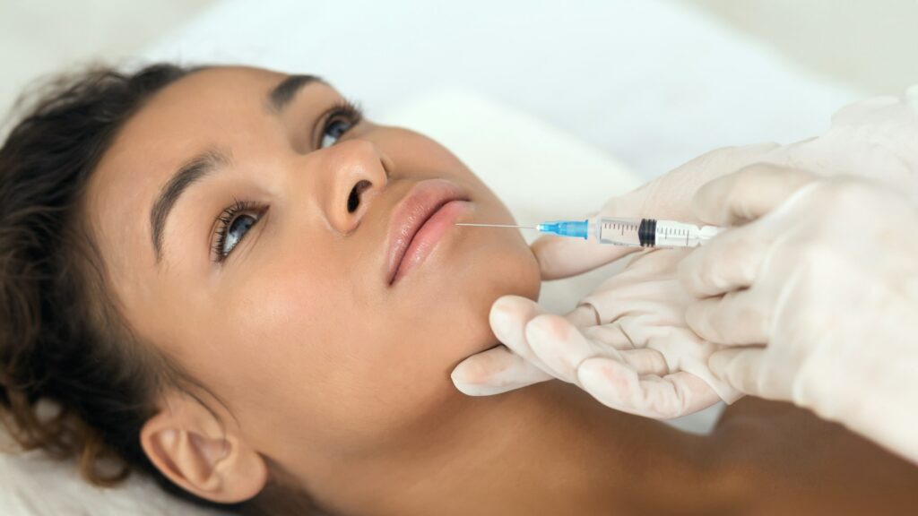 Lip Filler Aftercare. 
Close-up of aesthetic procedure on face for black lady