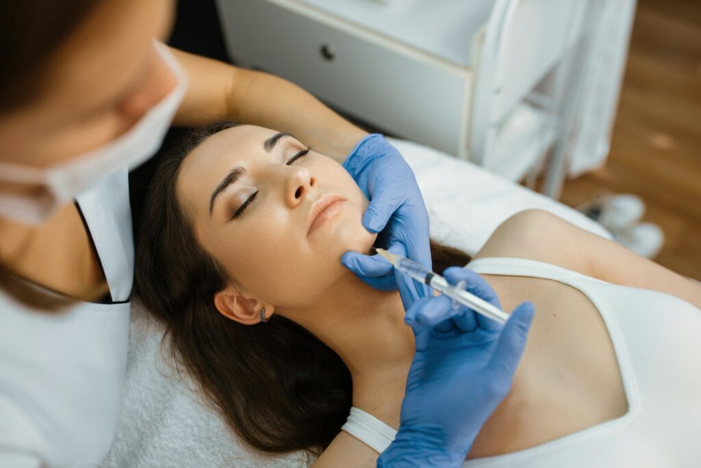 Cosmetician gives dimpled chin botox injection to patient