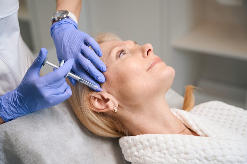 Adult lady getting temple fillers in beauty salon