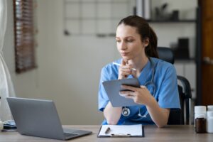 Female physician prescribing medication while using laptop computer.